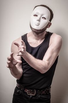 man with white mask on gray background