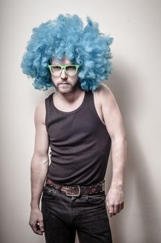 hipster stylish funny man with blue wig on gray background