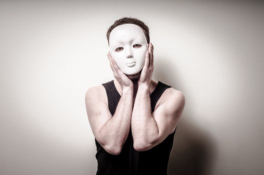 man with white mask on gray background