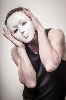 man with white mask on gray background