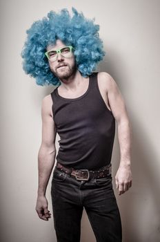 hipster stylish funny man with blue wig on gray background