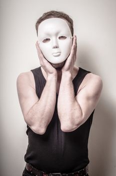 man with white mask on gray background