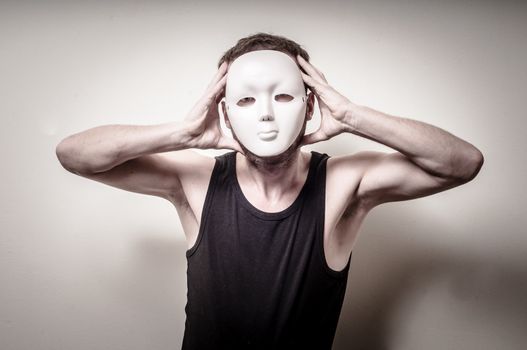 man with white mask on gray background