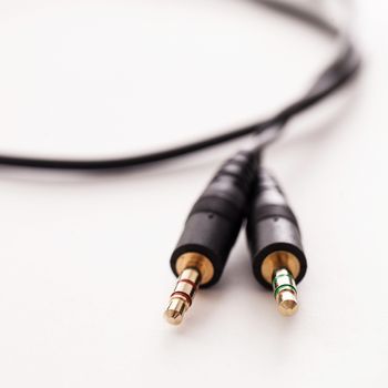 Black wire with two plugs on a white background