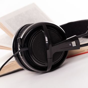 Big headphones and book on a white background