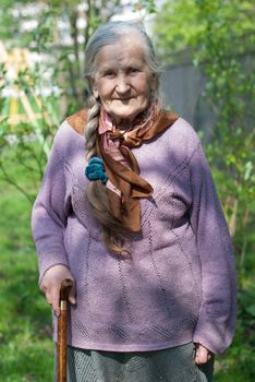 old grandmother with a long braid in the summer in the garden