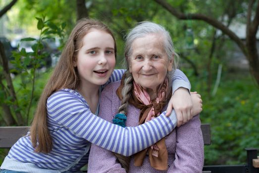 Grandmother and granddaughter laughing in the park in summer