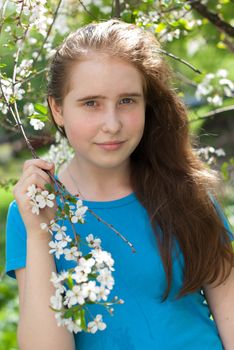 girl with long hair with blooming apple tree