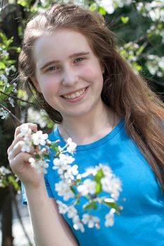 girl with long hair with blooming apple tree