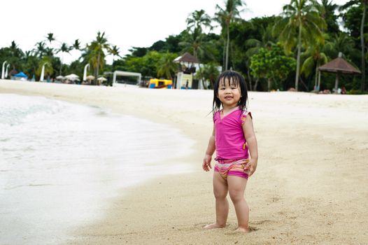 Young toddler at the beach having fun and is curios