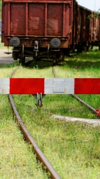 red white barrier to the railroad tracks with wagon