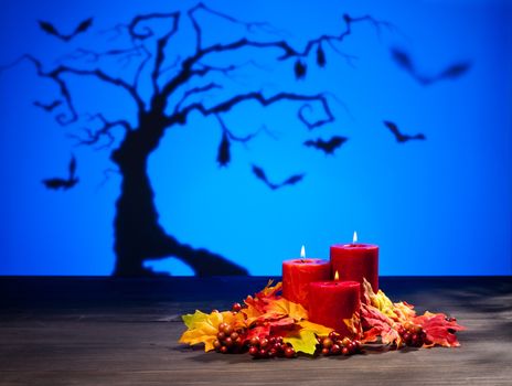 Candles in scary Halloween landscape with bats