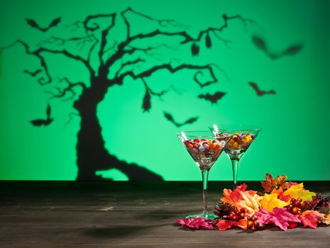 Halloween landscape a tree and a Martini glass with sweets