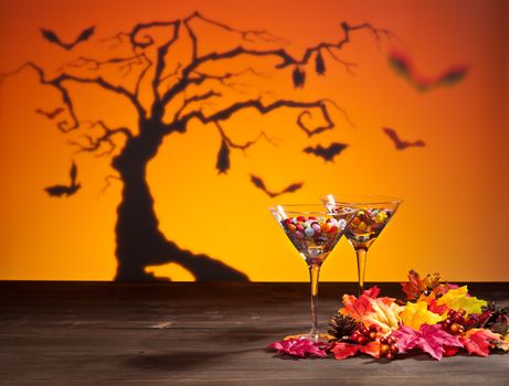 Halloween landscape a tree and a Martini glass with sweets