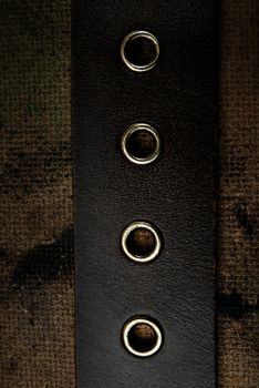 Close-up photo of the leather belt on a dirty background