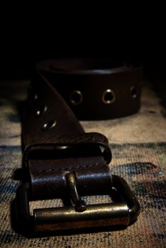 Close-up photo of the leather belt on the dirty surface