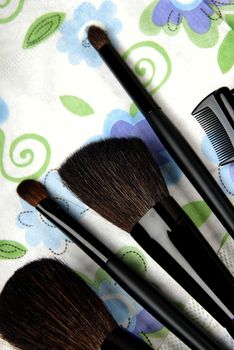Close-up photo of five make-up brushes on a colorful background