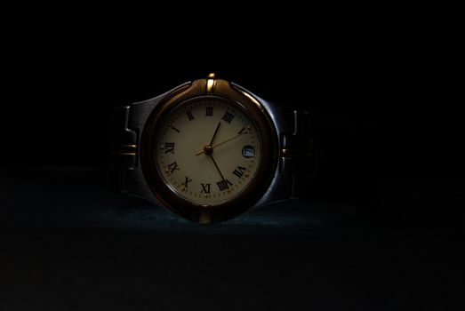 Silver wristwatch with chromium body on a dark background