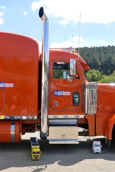 lorry driver having fun with a small truck radiocontrolled in front of its enormous truck