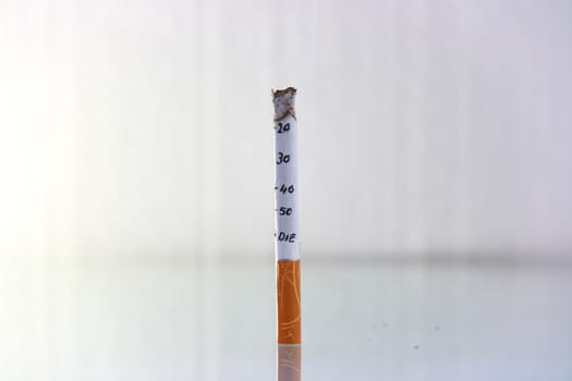 cigarette burning in front of white background