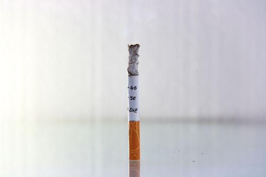 cigarette burning in front of white background