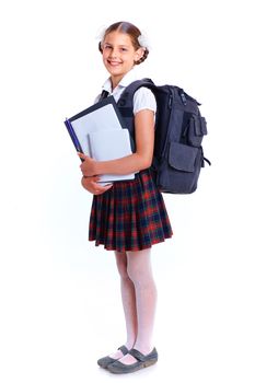 Education theme. Joyful schoolgirl smiling happily with backpack holding book
