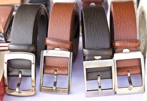 Closeup four leather belts on the table