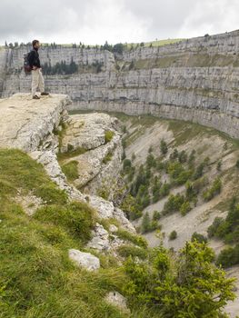 CREUX DU VAN, NEUCHATEL, SWITZERLAND - SEP 9: An unidentified hiker look at the natural rocky cirque of Creux du Van on September 9, 2010 in Neuchatel, Switzerland.