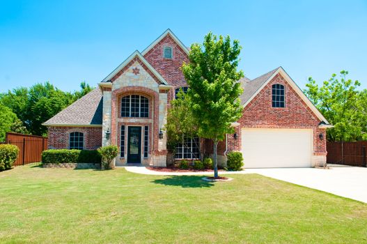 Two story brick residential home with the garage in the front.