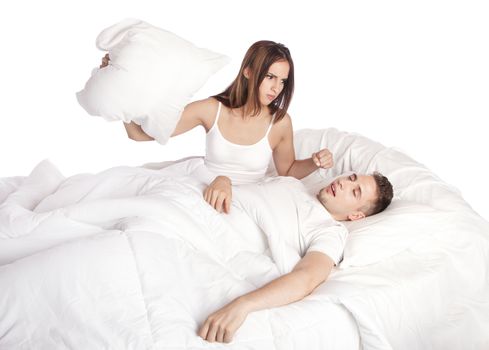Frustrated wife trying to stop husband from snoring with pillow in bed, isolated.