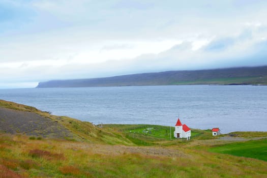 Small white church near the ocean, Iceland. Summer day.