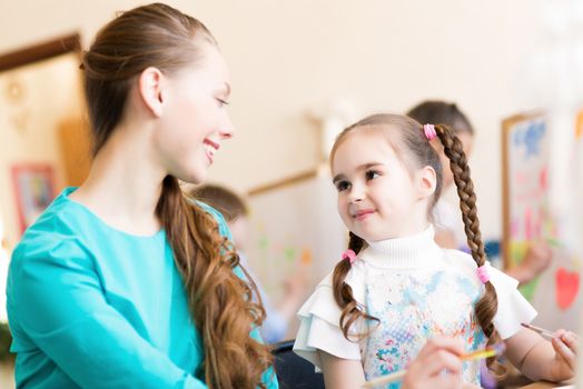 teacher talks to a schoolgirl, working at an art school