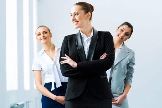 successful business woman in the office, colleagues stare over his shoulder