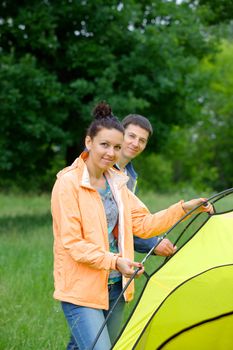 Young happy couple camping near tent in park