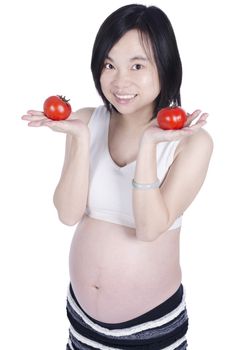 Beautiful pregnant woman holding fresh tomato by hand isolated over white background