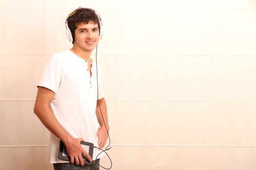 A young, latin man with a Tablet PC and headphones
