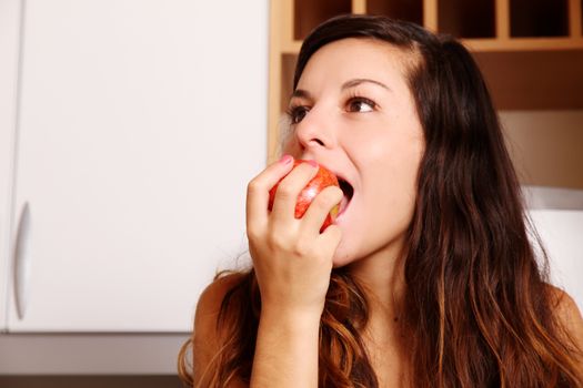A young adult woman eating a Apple.