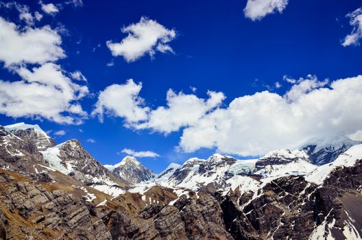 Himalayas mountains range snow peaks and blue sky with clouds