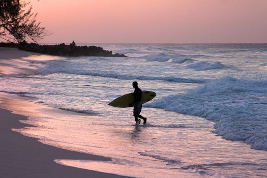 Man-surfer with board on a coastline. Bali. Indonesia