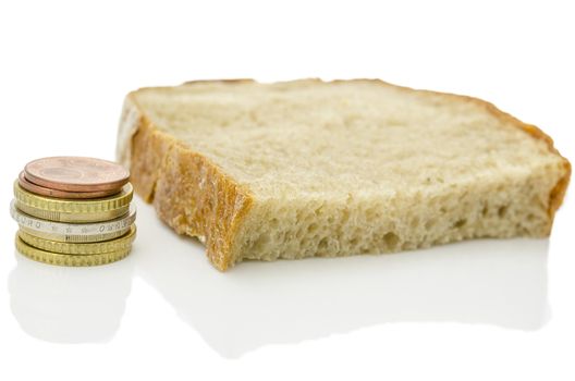 Piece of bread and Euro coins isolated over white background. Poverty concept.