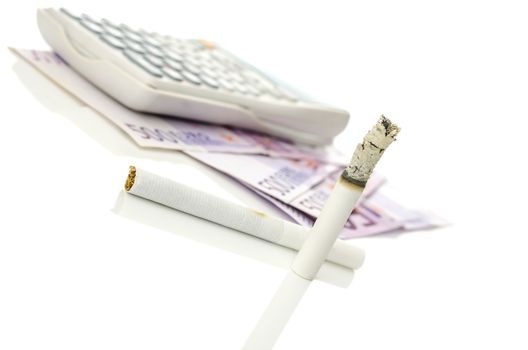 Burned cigarette with Euro money and calculator in background.