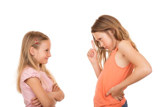 Big sister disagree pointing finger at her little sister because she did a silly, foolish, stupid thing or something wrong. Isolated on white background.