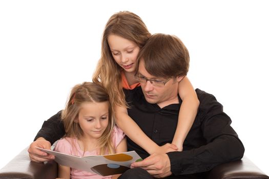 Father read a interesting story to his two daughters in a brown leather armchair. Isolated on white background.