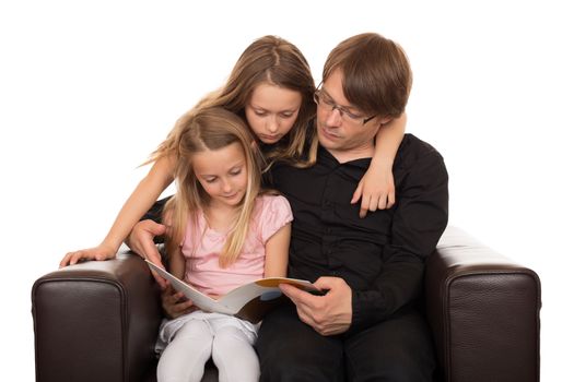 Family reading a story before going sleeping in a brown designed armchair. Isolated on white background.