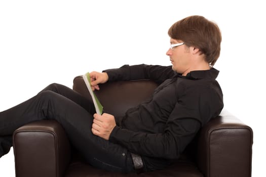 Man with glasses read a book quietly in his brown leather designed armchair. Isolated on white background.