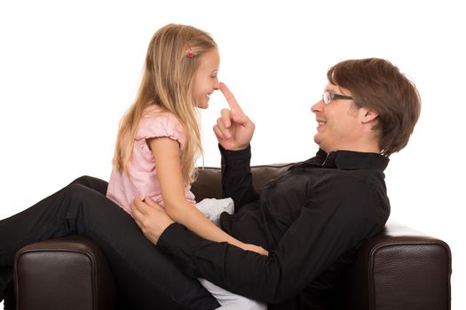 Young father play and smile with his daughter touching her nose with his finger in a brown leather armchair. Isolated on white background.