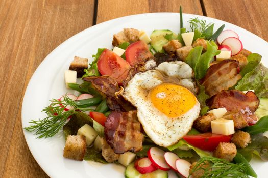 Peasant salad also called greek salad, village salad or country salad. Composed with lettuce, cucumber, onion, radish, fried egg and bacon, cheese, tomatoes, parsley and croutons.