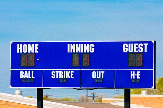 Baseball scoreboard with blue skky in the background.