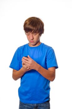 Young teen caucasian boy looking at cell phone isolated on white background.