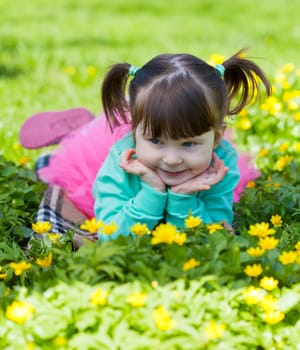 little girl lies on a grass